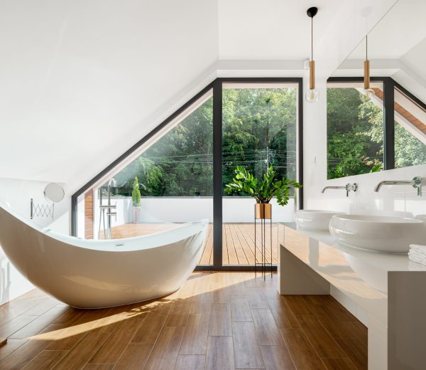 Elegant attic bathroom with bathtub Elegant attic bathroom with stylish bathtub, wooden floor and balcony door
